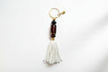 Keychain with beads and tassel on a gray background