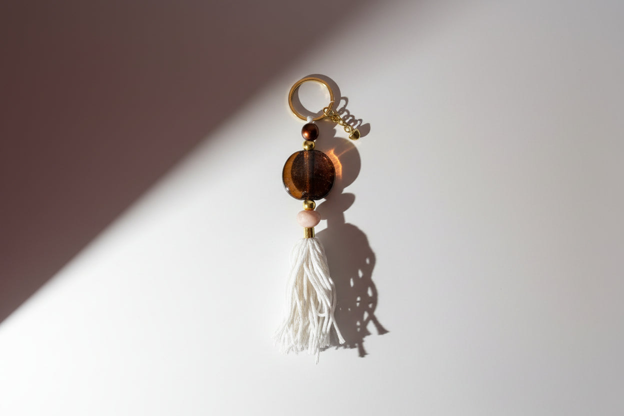 Keychain with beads and tassel on a beige background