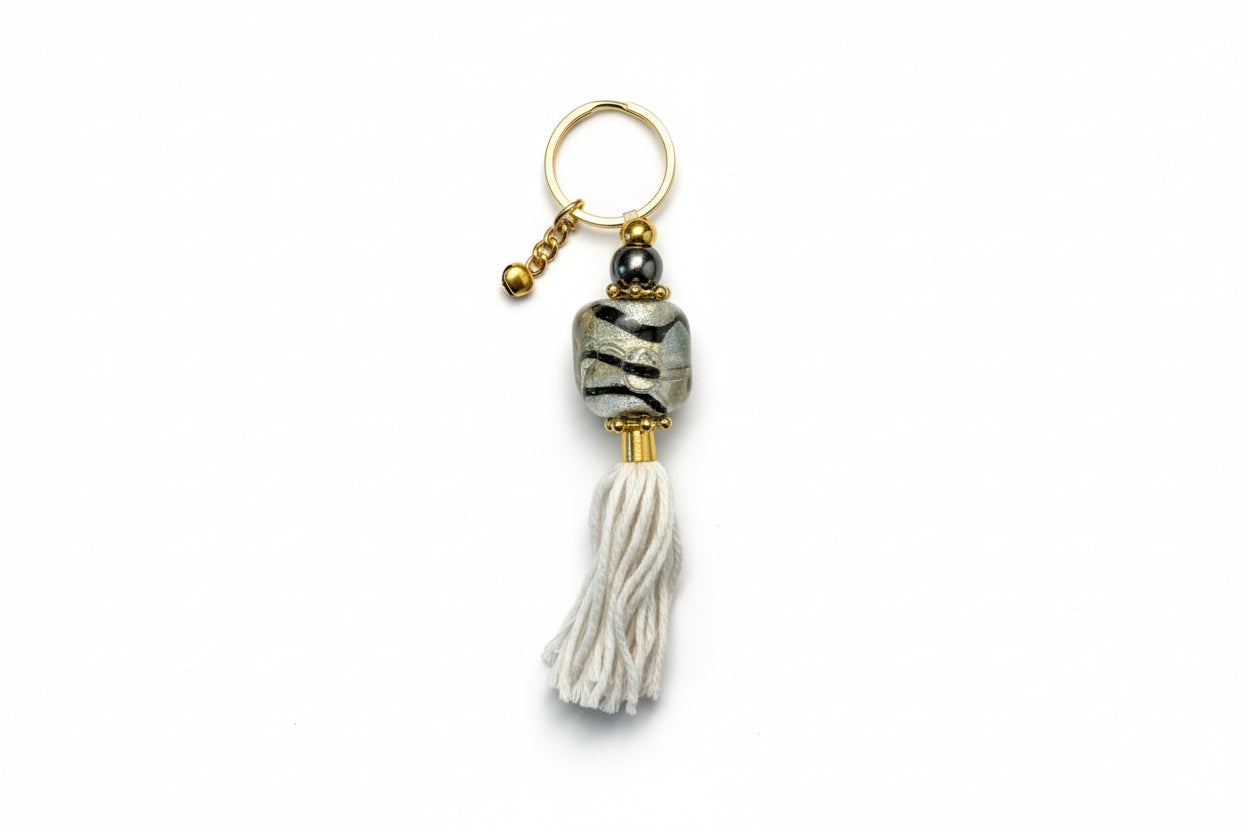 Keychain with tassel and decorative bead on a beige background